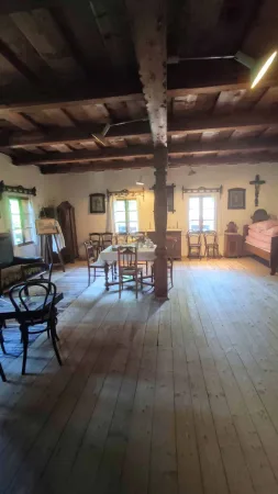 Prostorná světnice s dřevěným stropem a starým nábytkem ve skanzenu