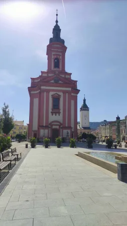 Barokní kostel s výraznou červenobílou fasádou na náměstí v Hranicích