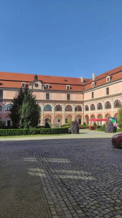 Nádvoří zámku Žerotínů ve Valašském Meziříčí se stromem a fontánou v pozadí