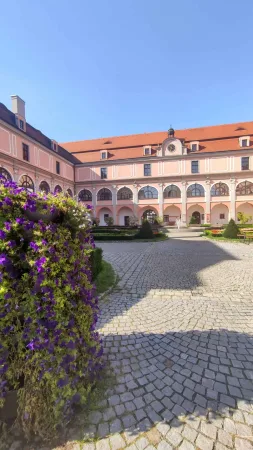 Renesanční nádvoří zámku Žerotínů ve Valašském Meziříčí s věžními hodinami a kašnou