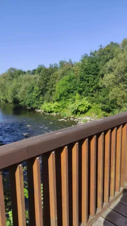 Pohled na klidnou hladinu řeky Bečvy z dřevěné lávky