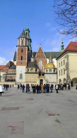Fronta turistů před Wawelskou katedrálou v Krakově se zlatou kupolí Zikmundovy kaple