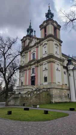 Barokní bazilika na Skałce v Krakově s pastelovou fasádou a dvěma věžemi za zataženého dne