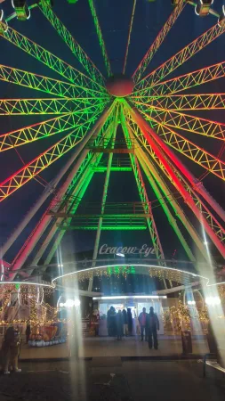 Pohled vzhůru do barevně nasvícené konstrukce vyhlídkového kola Cracow Eye v Krakově
