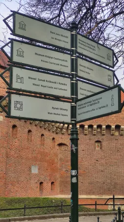 Turistický rozcestník se směrovkami k Wawelu a Hlavnímu náměstí v Krakově