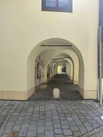 Kilátás egy hosszú folyosón ismétlődő ívekkel Sopronban
