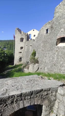 Kamenné hradby hradu Trsat s vlajkou a zbytky staré věže