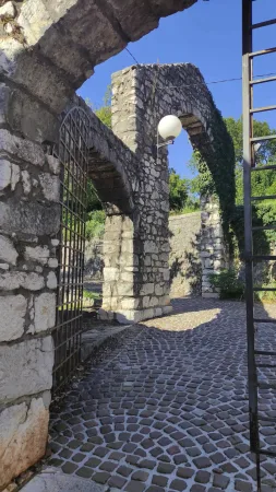 Kamenná brána s lucernou a kovanou mříží u vstupu do hradu Trsat
