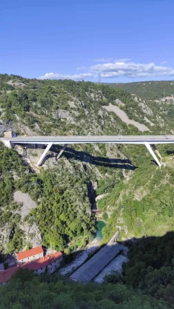 Vysoký silniční most nad zeleným kaňonem řeky Rječiny