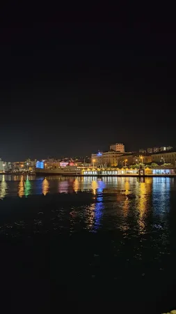 Noční přístav v Rijece s loděmi a odrazy světel na hladině