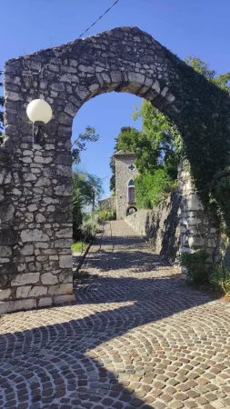 Průchod kamennou branou s výhledem na kapli uvnitř areálu hradu Trsat