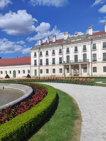 Boční průčelí zámku Esterházy se zahradou a lavičkami