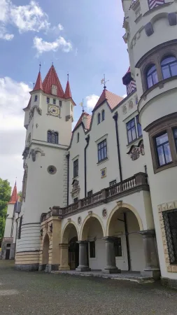 Arkádová chodba u vstupu do zámku Žinkovy s věží s cimbuřím v pozadí