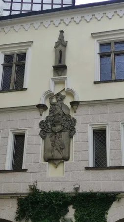 Detail kamenného reliéfu s erbem na fasádě zámeckého nádvoří v Blatné