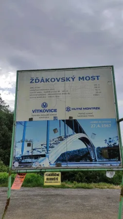 Informační cedule s historií a technickými parametry Žďákovského mostu u příjezdové cesty