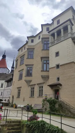 Nádvoří zámku Blatná s výhledem na věž a kostelní věžičku v pozadí