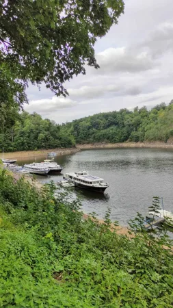 Přístaviště výletních lodí na Vltavě pod zámkem Orlík obklopené zalesněnými kopci