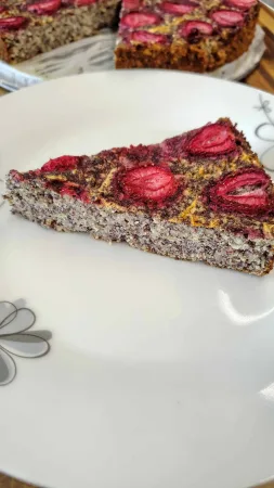 Une part de gâteau au pavot avec des fraises dans une assiette
