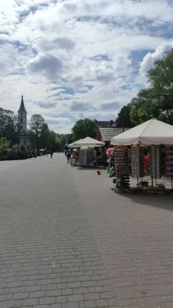 Hlavní pěší zóna ulice 1 Maja se stánky a kostelní věží v pozadí