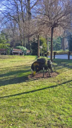Socha obřího čmeláka stojící na trávníku v areálu krakovské zoo