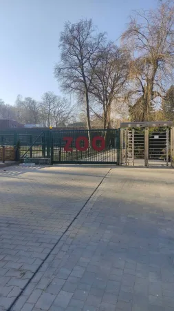 Zelená vstupní brána do krakovské zoo s červeným nápisem ZOO